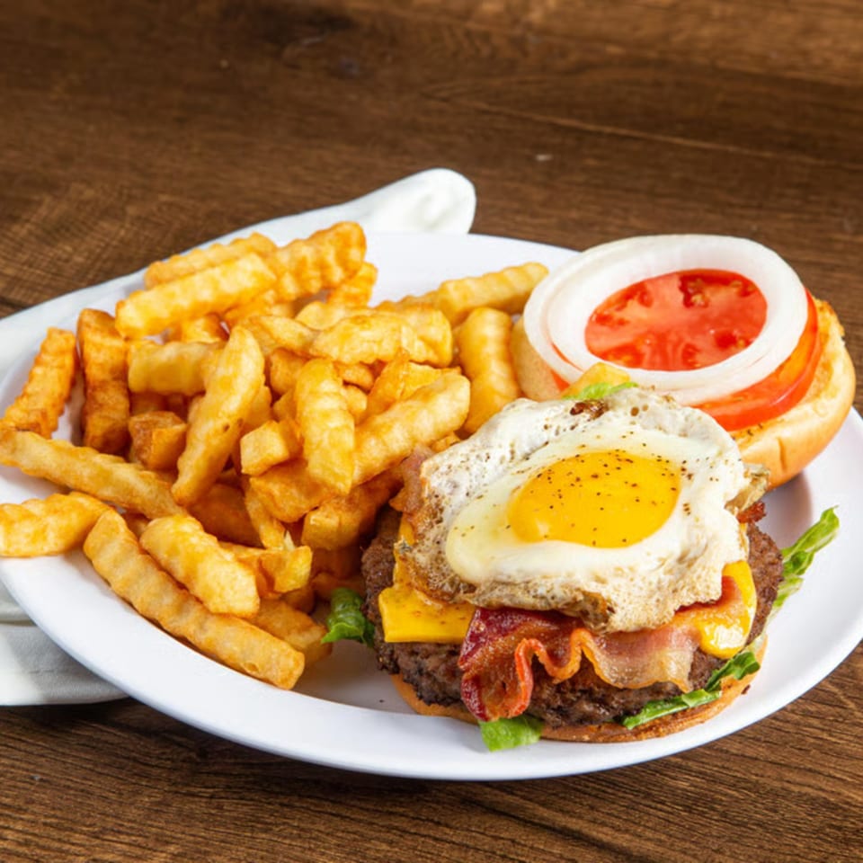 A Rickey's Sports Bar & Grill burger with bacon, cheese, fried egg, and fries.